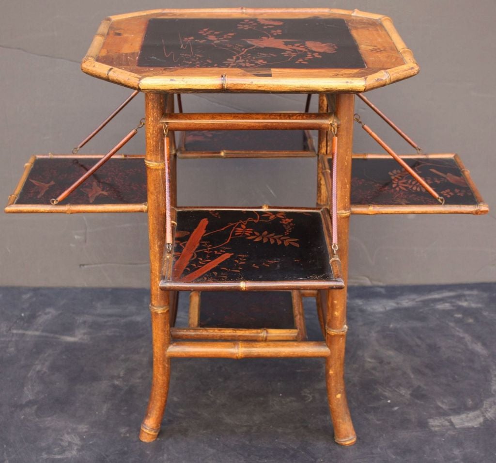 An English bamboo tea table featuring an eight-sided lacquered top with parquetry around the circumference, framed in bamboo. Over a bamboo support with four folding lacquer panel sides, used for serving.

Dimensions (closed): H 28 1/4