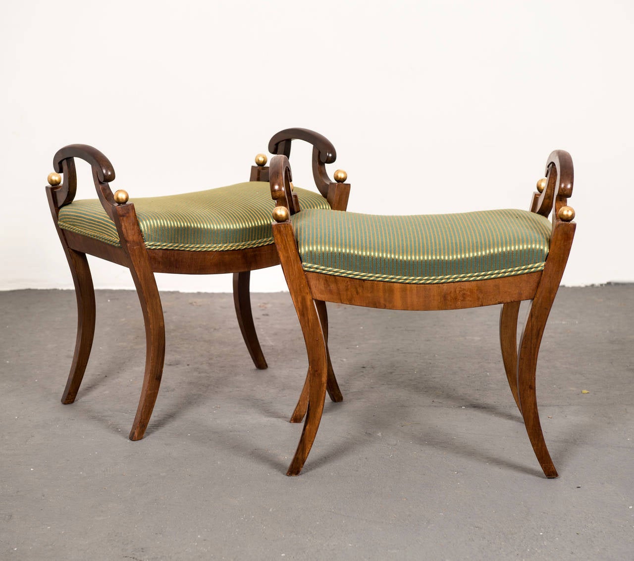 A pair of mahogany benches with a gilded ball detail, made during the Karl Johan period ca 1810-1830.