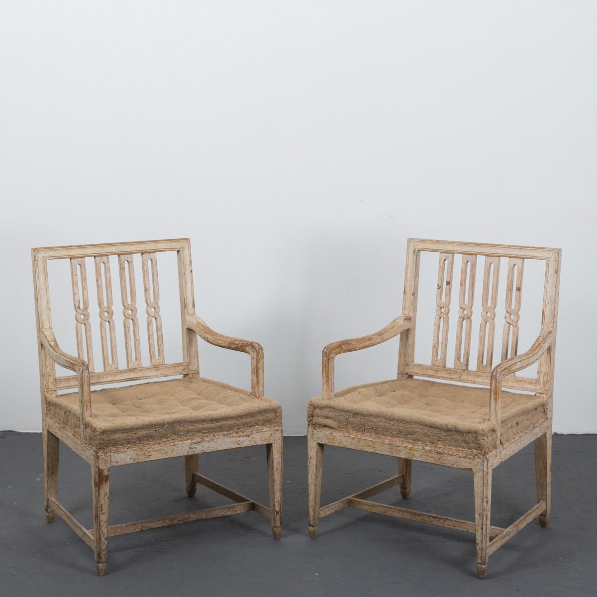 An exquisite pair of Swedish armchair made during the Gustavian period ca 1790. Wide seat and back in all original condition (updated seating). Beautiful original paint with charming patina. Rectangular back splat with twisted grid spindles. Softly