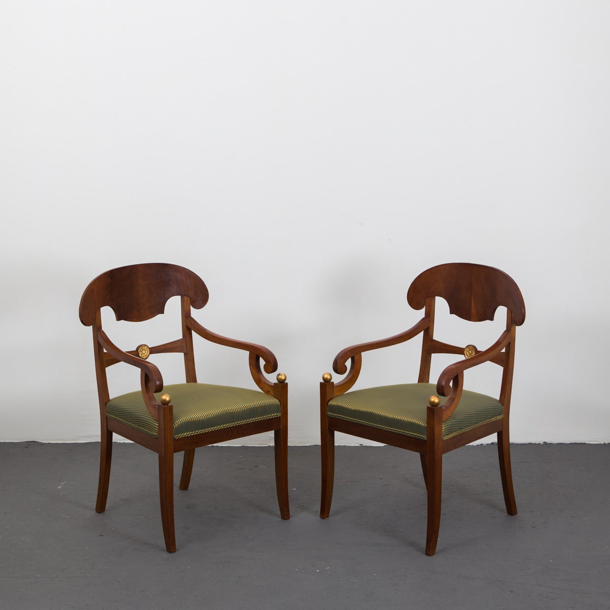 Armchairs Pair Swedish Empire period 19th century mahogany gilded details Sweden. A pair of Karl Johan/Biedermeier armchairs in mahogany and giltwood. Back splash shaped like a napoleon hat. Out curved back legs.
