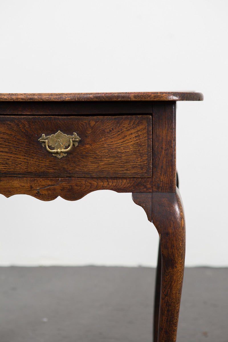 Side Table English Oak Baroque Period England. A beautiful side table made in oak from England. Frieze with 2 drawers with brass hardware and cabriole legs. A mid-brown color. 