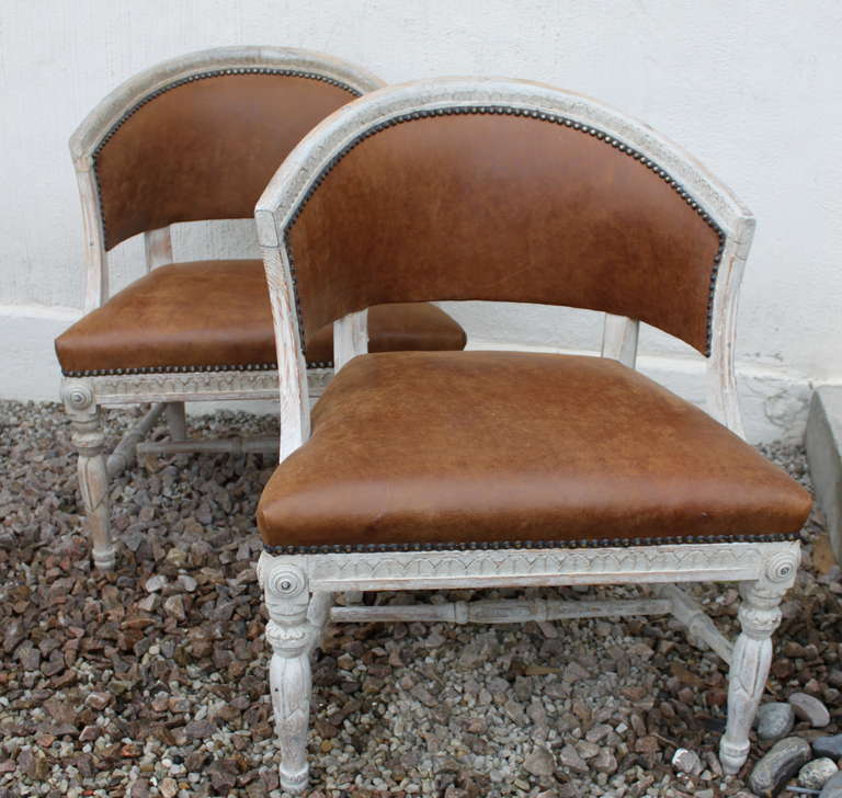A lovely pair of barrel backed chairs made in Sweden during the Neoclassical time / Gustavian period. Ca 1790-1810. Original paint. Upholstered in a vintage leather.