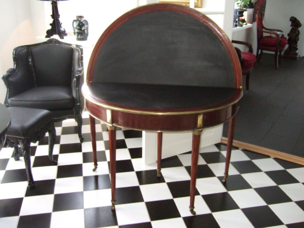 A french game table in mahogany decorated with brass detailing.