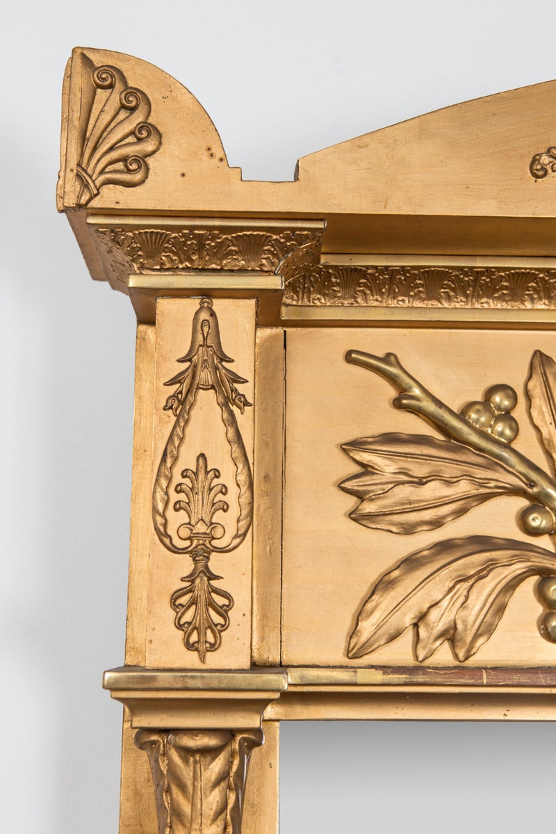 Gilded mirror made during the Empire period in Sweden during the first half of the 19th century. Beautifully decorated with symbols characteristic for the period such as a lyre, a medusas head, palm leaves and columns.