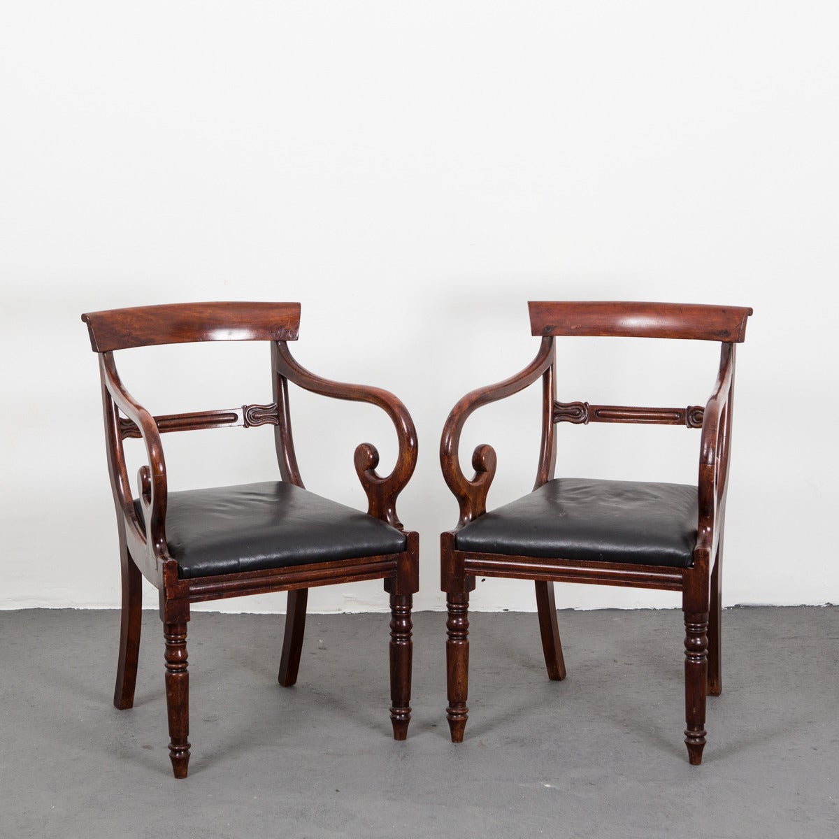 English armchairs made during the Regency period, early 19th century. Frame mahogany and upholstered in a soft black leather.