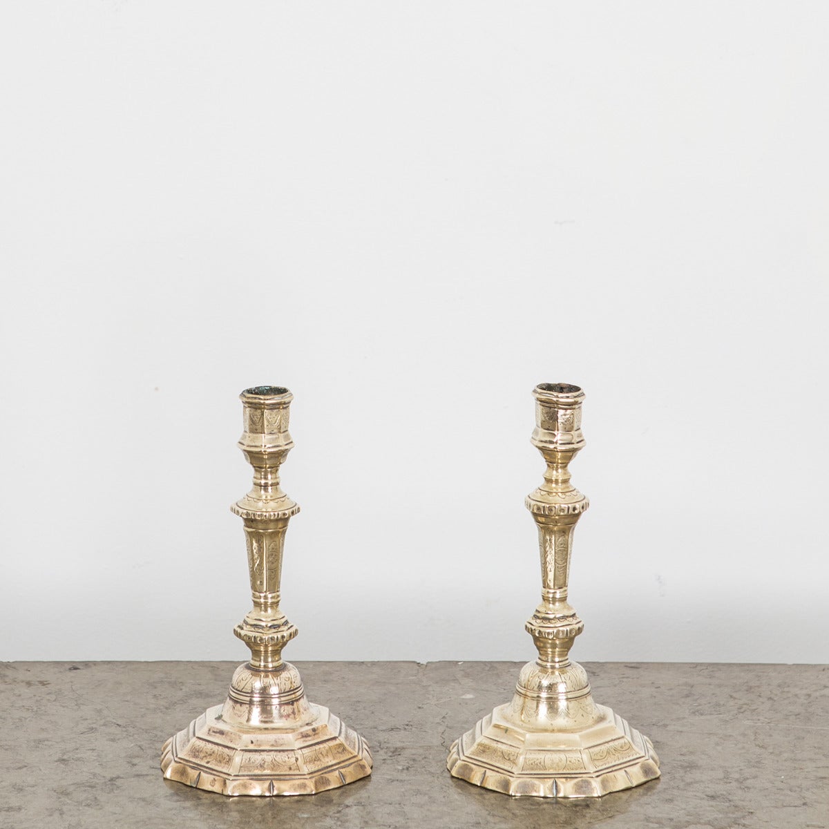 A pair of French Baroque/Louize XIV candlesticks in lovely patinated brass. Decorated with flowers and swags. Octangonal base. All original condition.