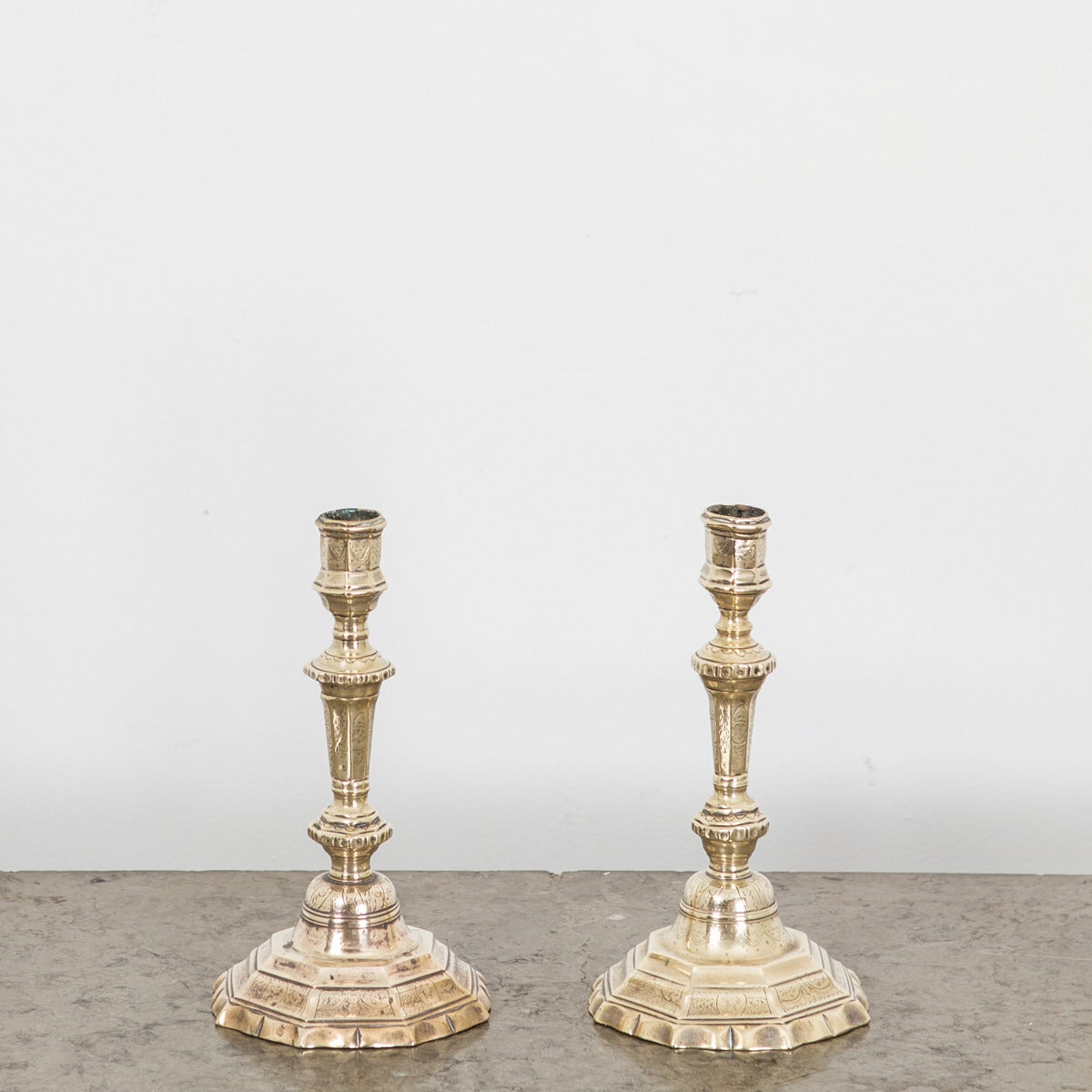 Coppia di candelieri francesi barocchi/Louize XIV in ottone patinato. Decorato con fiori e festoni. Base ottangolare. Tutte le condizioni originali.