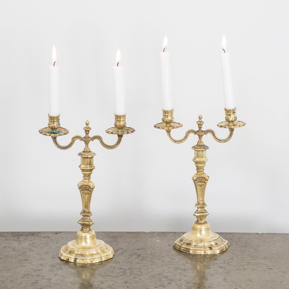 A pair of French brass candelabras made during the Baroque period ca 1700. 2 arms on each candelabra for candles. 