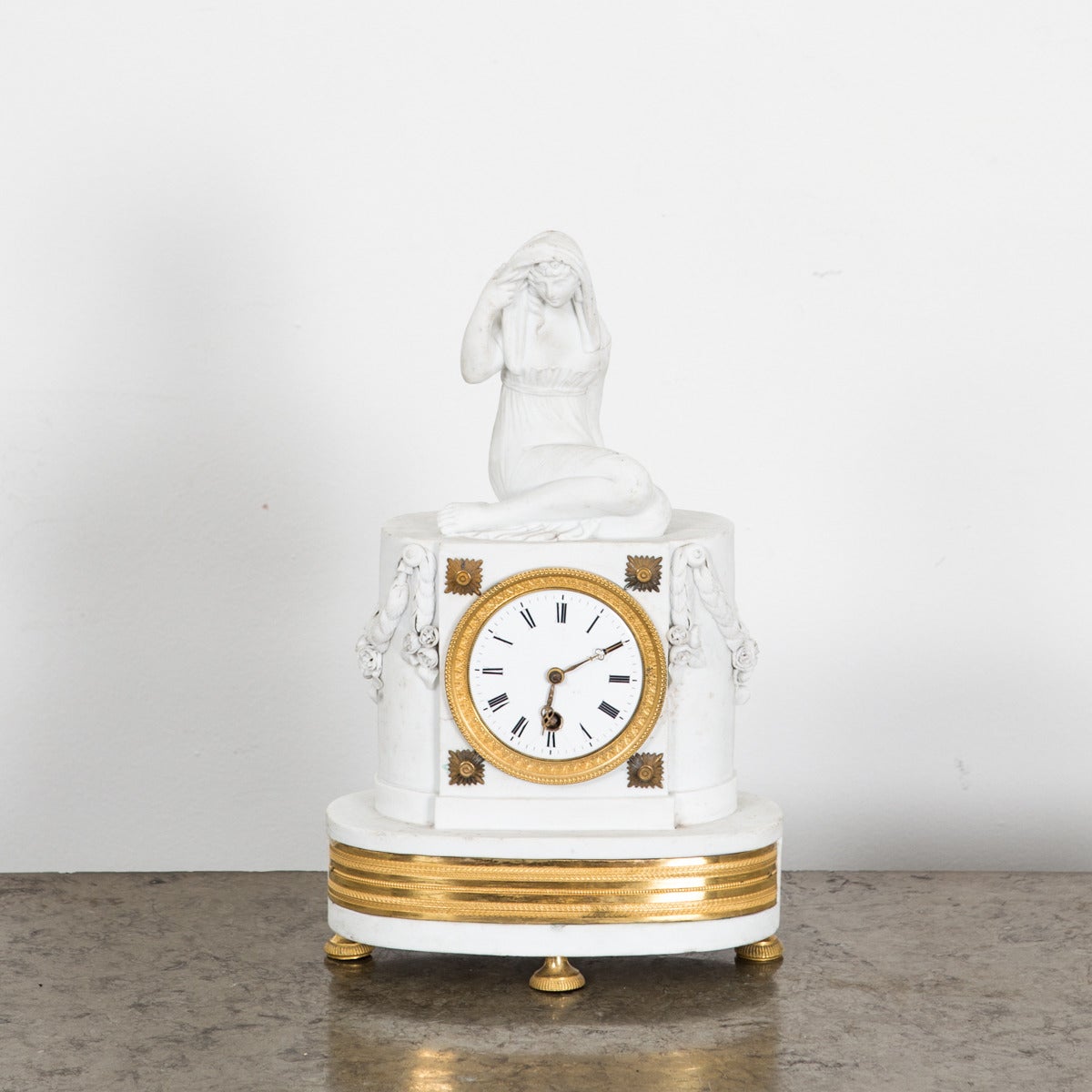 Mantle Clock French Neoclassical White Gilt bronze France. A mantle clock made in France during the Neoclassical period ca 1790-1810. White with gilt bronze details. Decorated with laurel swags 