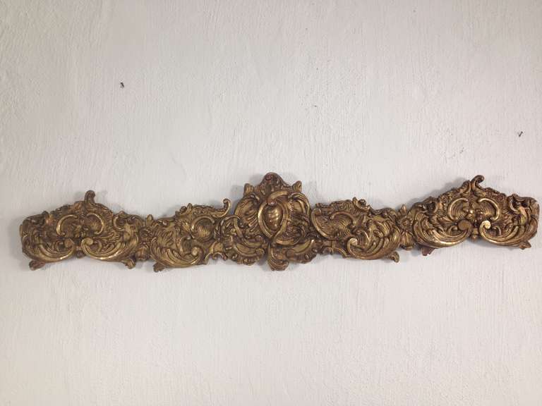 A crown molding carved in wood with a gilded surface. Details typical for the period such as the rocaille and acanthus leaves and S shapes. All original.