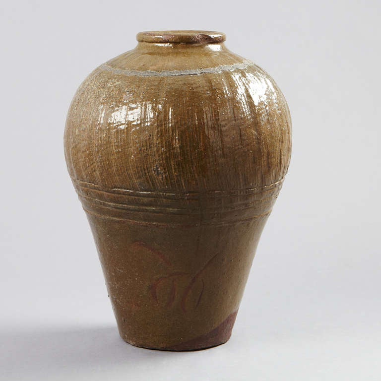 An urn made in southeastern Asia in brown glazed pottery. Decorated with patterns.