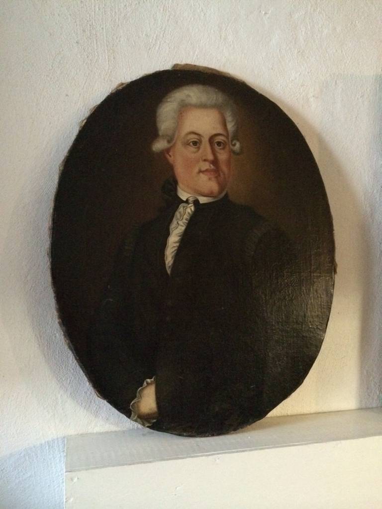 Oil painting in an oval shape of a 18th Century gentleman. Rough edges nailed to wooden frame. Unsigned. Probably one of a pair where the 