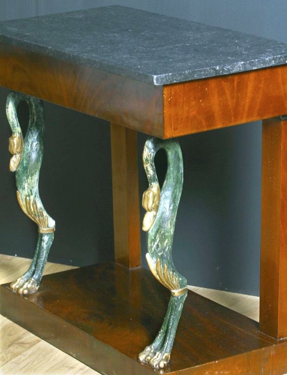 Austrian console table from the Karl Johan Period in mahogany and a top of black marble. Drawer in frieze. The table is decorated with Swans that are painted in a green color to imitate oxidized copped with gilded details. The swans are inspiration