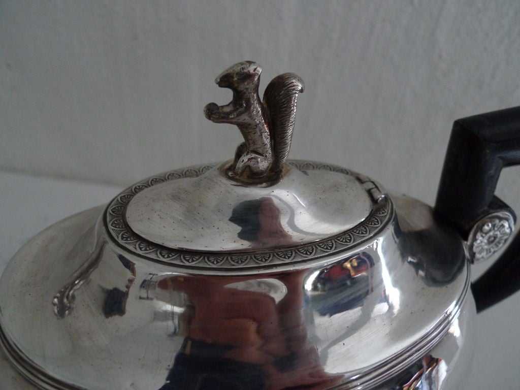 Teapot Austrian Silver Empire period Austria. An Empire silver teapot with a squared handle made in ebonized wood. Pot is decorated with fantasy animals such as horse head and a squirrel top on lid.