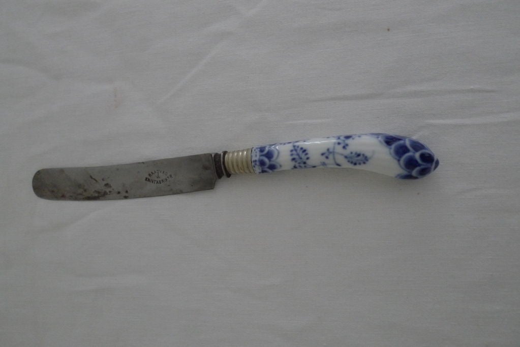 A set of Danish knives with porcelain handles attached by a silver ring. Maker: Musselmalet. The Royal Danish porcelain.