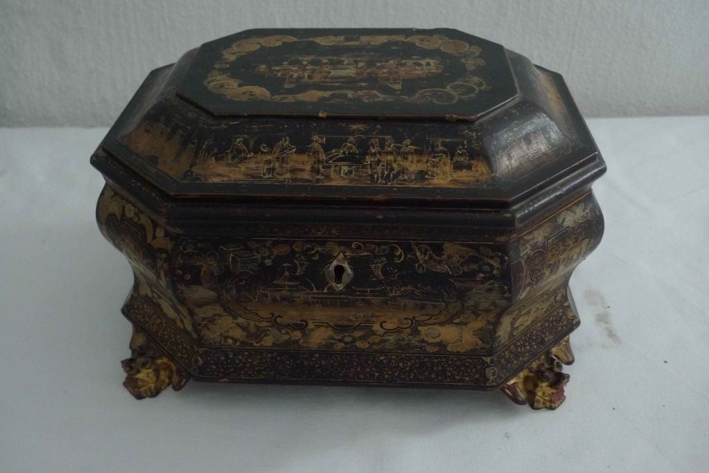 Box Chinese Black Gold Chinoiserie 19th Century China. A box made in China during the 19th century. Black lacquer decorated with gilt paintings. Body with a Rococo shape standing on feet looking like dragons with red detailing.
