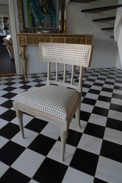 A pair of side chairs made in Sweden during the Gustavian period ca 1775-1800. They have a curved back splat with turned legs with channels. Semi upholstered back and an upholstered tuck in seat.