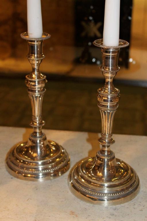 A pair of argent hache candlesticks from France ade during the Louis XVI period. Decorated with neoclassical attributes such as pearlbeading and channeled stems.