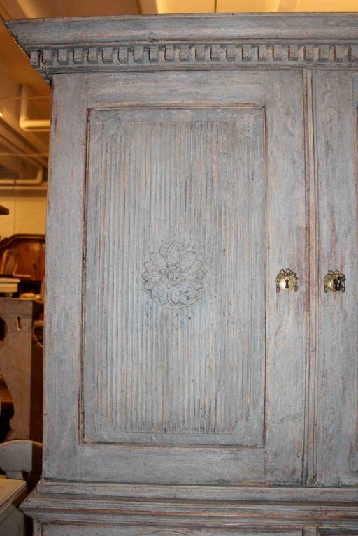 A blue painted, all original, Gustavian cabinet from Sweden. 1790-1810. Stuning carvings decorating the doors and drawers.