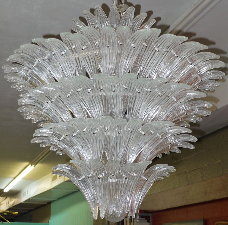 Massive murano palm chandelier featuring 5 layers of overlapping curved palm leaf looking pieces of murano glass.  Inside the bottom tier is a 4.5 inch quilted blown glass sphere.  This is one of a pair available.  Measurements are for fixture only.