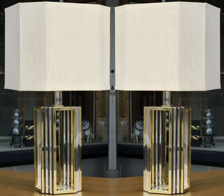 Stunning pair of Romeo Rega lamps in chromed steel and polished brass, featuring a 3 way switch to alternate between torchiere lighting and reading lights.  All the sockets have been replaced and updated.