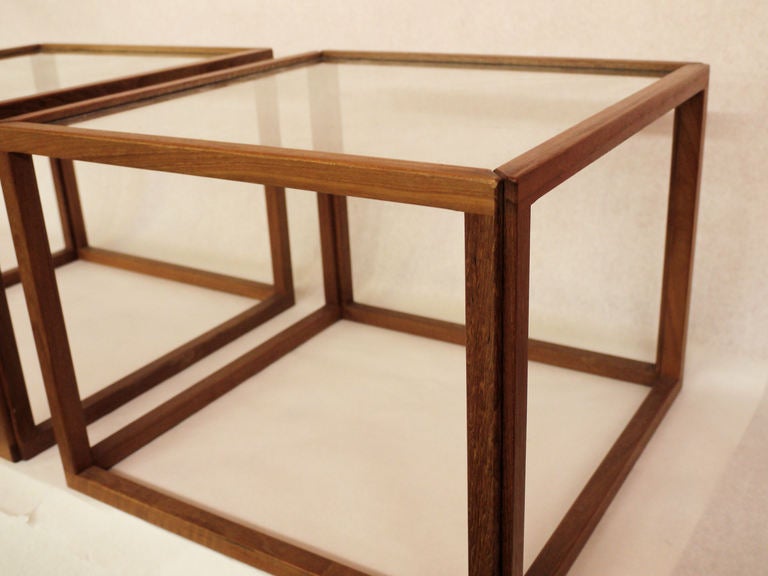 Pair of elegant teak tables designed by Kai Kristiansen featuring an intricate corner based joinery which holds the glass securely.  Could be used together as a coffee table or as end or side tables depending on the seating.