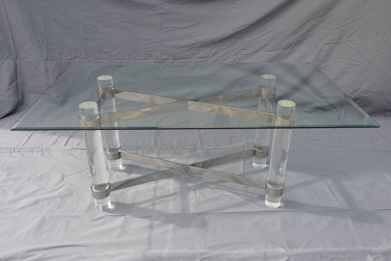 A magnificent lucite dining table designed by Paul M. Jones with thick solid Lucite columns for legs and chrome stretchers that are wrapped around each leg near the top and base.