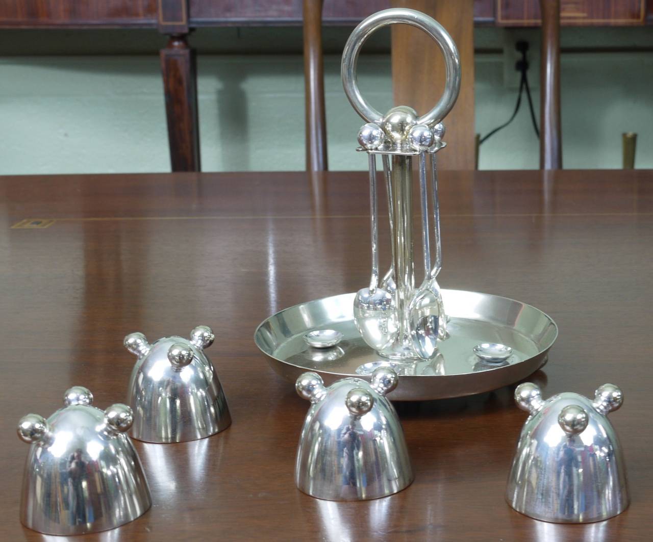 Luxurious silver plate soft boiled egg serving set in the manner of Christopher Dresser and the cups are similar in design to egg cups by Fritz August Breuhaus de Groot.