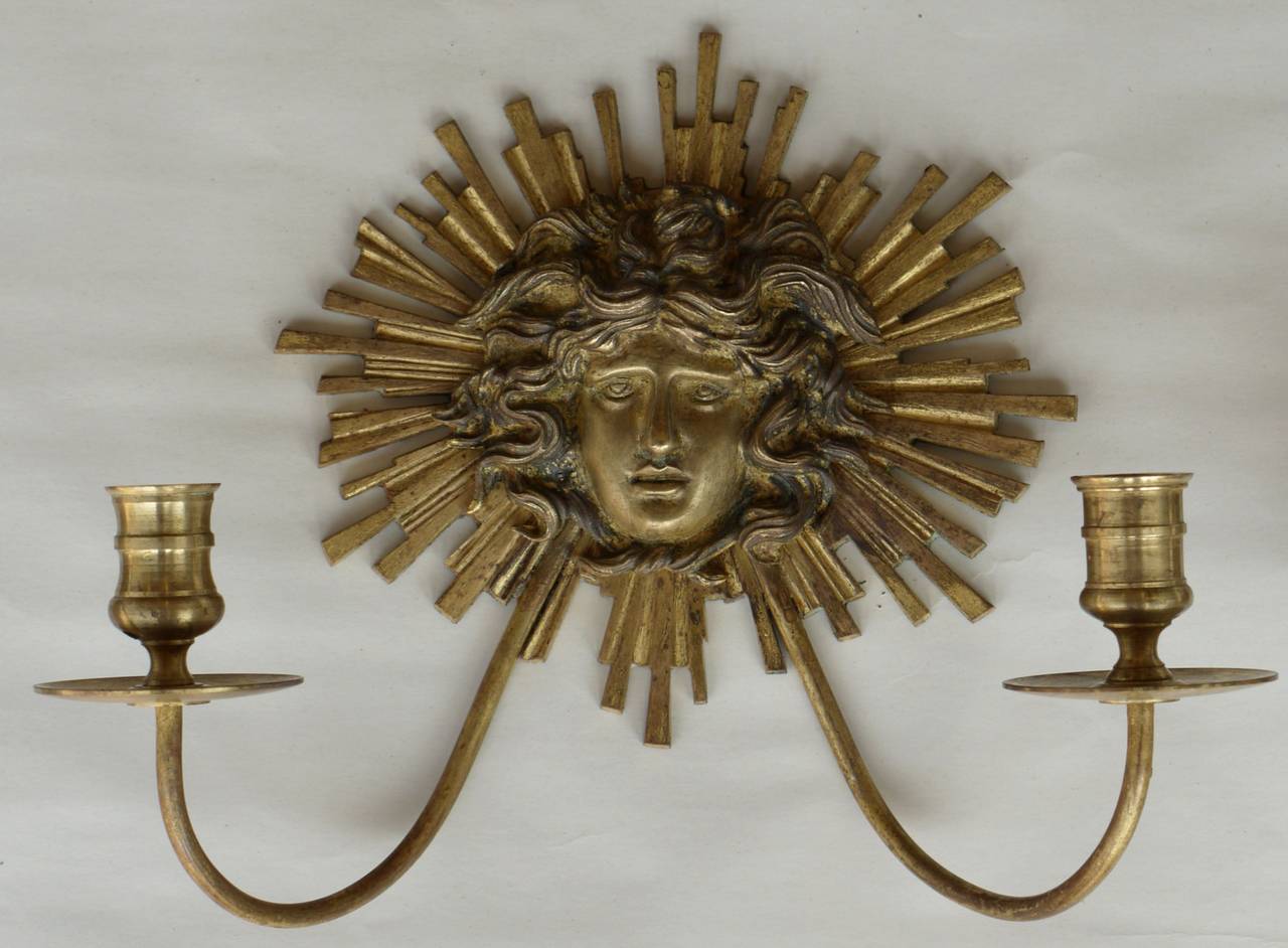 Stunning pair of gilded bronze sconces after a design by Andre Arbus stunning neoclassical style and perfect scale.   They have been drilled so that they can be wired for electricity if wanted.
