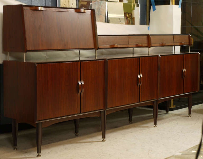 Stunning rosewood sideboard attributed to Dassi, which shows heavy influences to the work of Ico Parisi.  Bent ply handes which offer a very formal but also relaxed elegance to the piece.  Featuring four drawers and a drop front bar which are