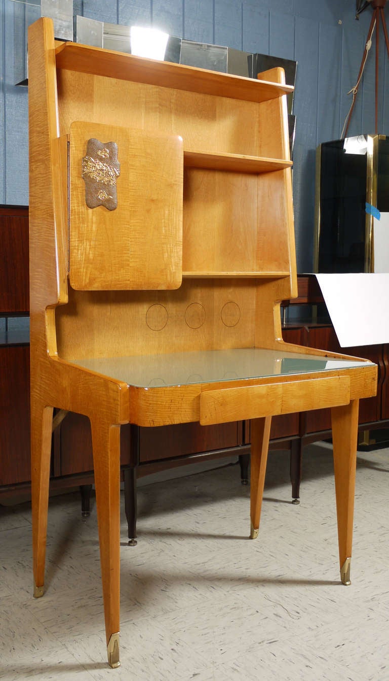 Wonderful Italian pear wood secretary featuring a reverse painted glass top supported by compass like legs ending in heavy brass sabots.  Above the desk are book shelves and an off center cabinet featuring a gilt wood and gesso frieze.  Would make a