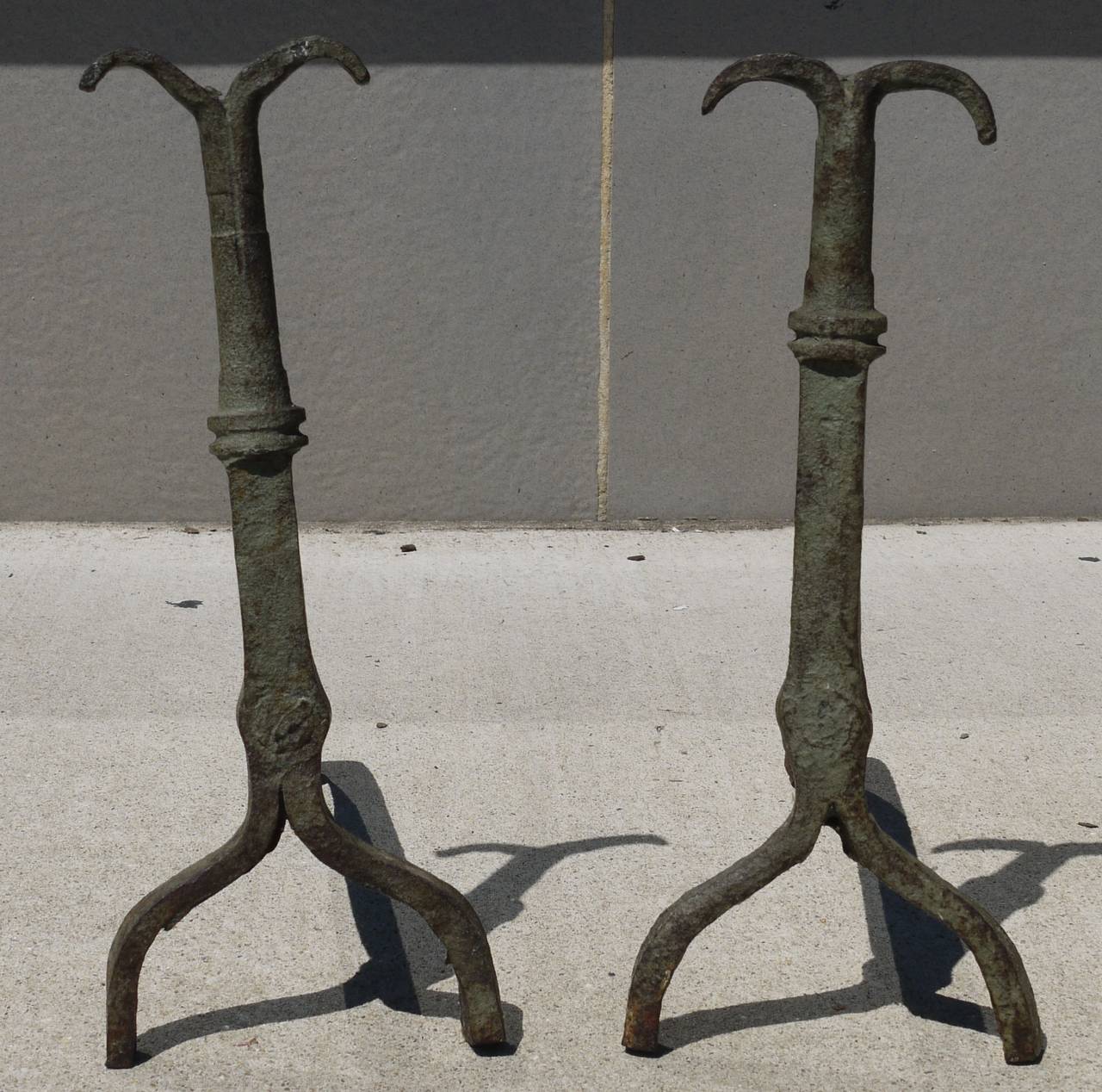 Stunning Folk Art andirons with very Giacometti lines but pre-Giacometti. I believe these are American and from Shanendoah Valley region of Virginia. One is signed with an E stamp on back. Remanents of old green paint give them a verdigris look,