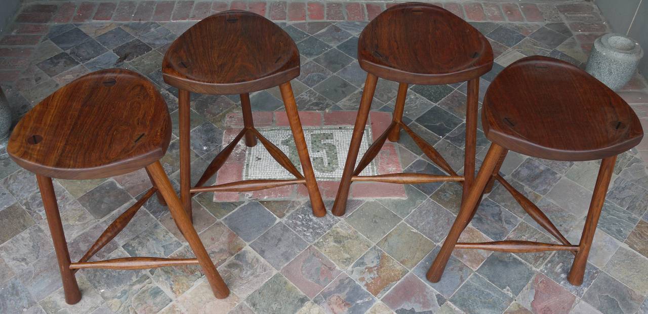 Nice set of sculptural counter-height stools featuring turned legs with a slight flare before the leg meets the floor.  Triangular walnut seat with splined legs visible from the top.  Really nicely made and a good design overall.