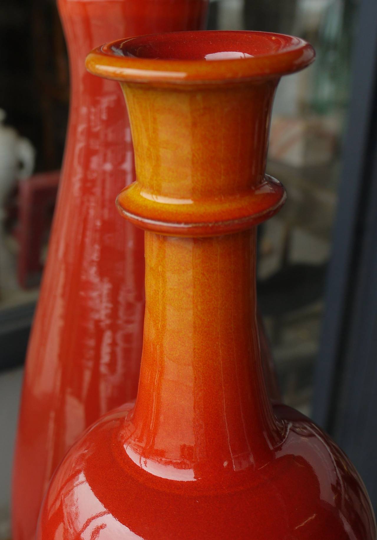 Stunning grouping of Italian ceramic vases in varying shades of orange and red bottle form vases made in Italy. Two of the vases are signed Studio Esposito and one is signed Duca di Camastra. Largest vase measures 7