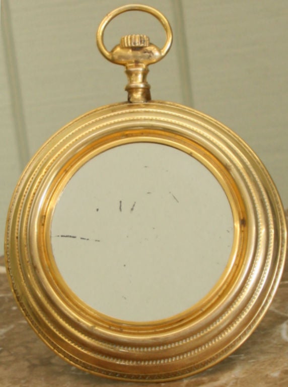 Gilt 1940's Italian pocket watch standing mirror or small hanging mirror attributed to Fornasetti.  Market on back made in Italy.