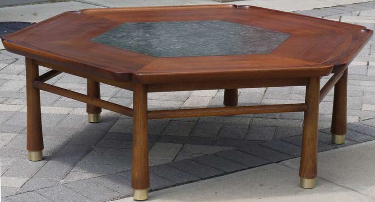 Stunning hexagonal coffee table with inset piece of slate supported by reverse taper legs with heavy brass caps.  Possibly designed by Harvey Probber or Kipp Stewart.