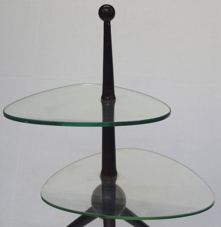 This is a little gem of a table.  Dark lacquered Ash tripod table which supports two amoeba shaped glass tops.  A handled version is often attributed to Gio Ponti or Pietro Chiesa for Fontana Arte. Measurements below for structure.  Bottom Glass