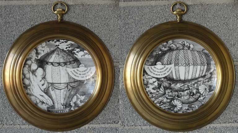 Pair of dated 1955 Plates by Fornasetti mounted in pocketwatch frames i believe are original and also by Fornasetti.  Wonderful display and can be used flanking a piece of furniture or stacked on a narrow wall.