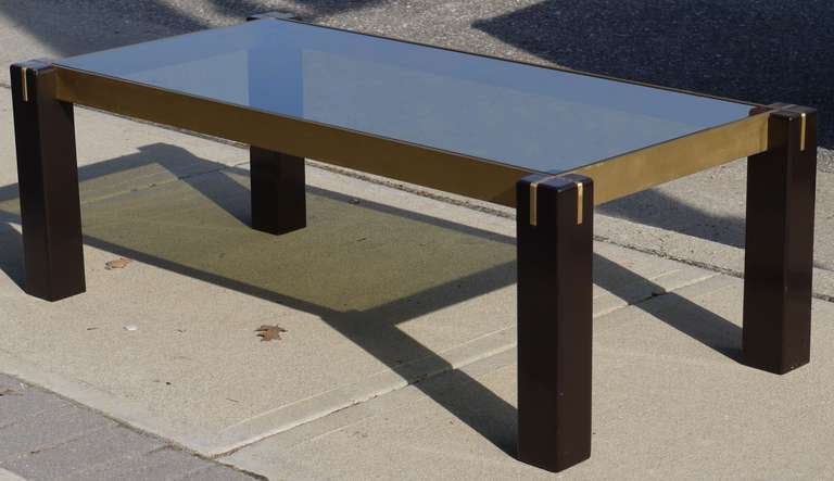 Love the simplicity and scale of this Italian coffee table featuring brown lacquered legs and bronzed steel apron which are slotted to fit together and are level with the tops of the legs.  The design is well thought out as the smokey glass top