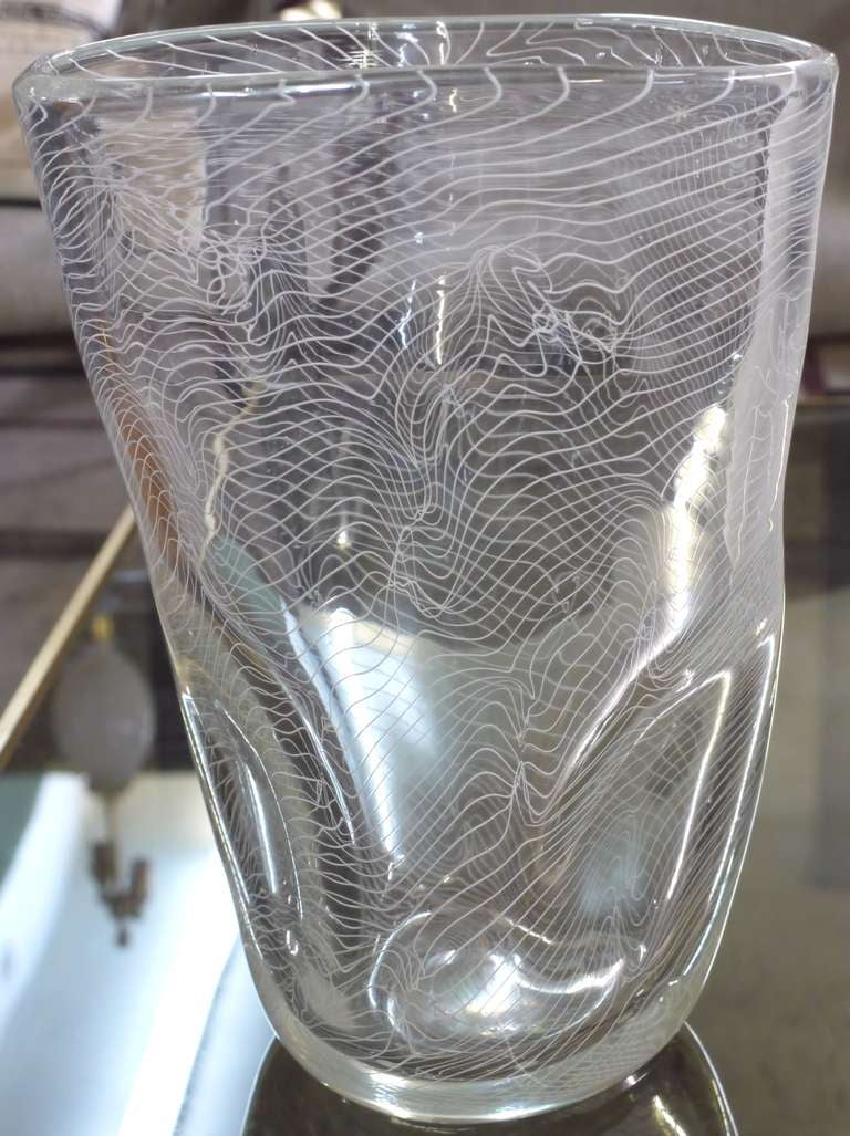Große optische Murano-Vase mit gedrehten spiralförmigen weißen Glaslinien, die in klarem Glas aufgehängt sind.  Die Linien spielen ständig mit dem, was im Vorder- und Hintergrund steht.  Schwer zu fotografieren, da die Kamera nicht weiß, wo sie