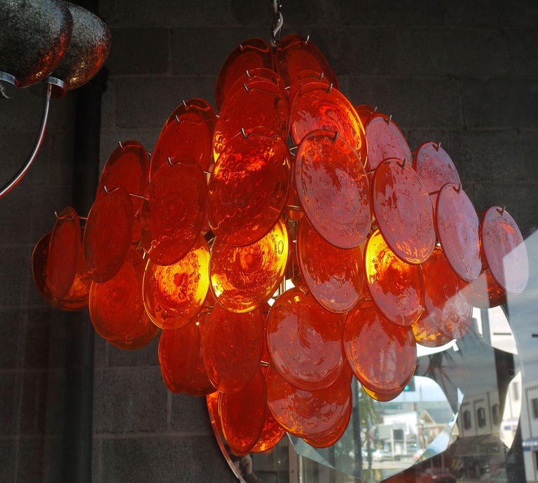 Show stopping Visotsi Chandelier with 64 vibrant orange Murano glass discs.  We have this hung in our window and it lights up the street at night in the orange color.  There's 8 adjustable edison sockets providing a ton of light and color.  Stucture