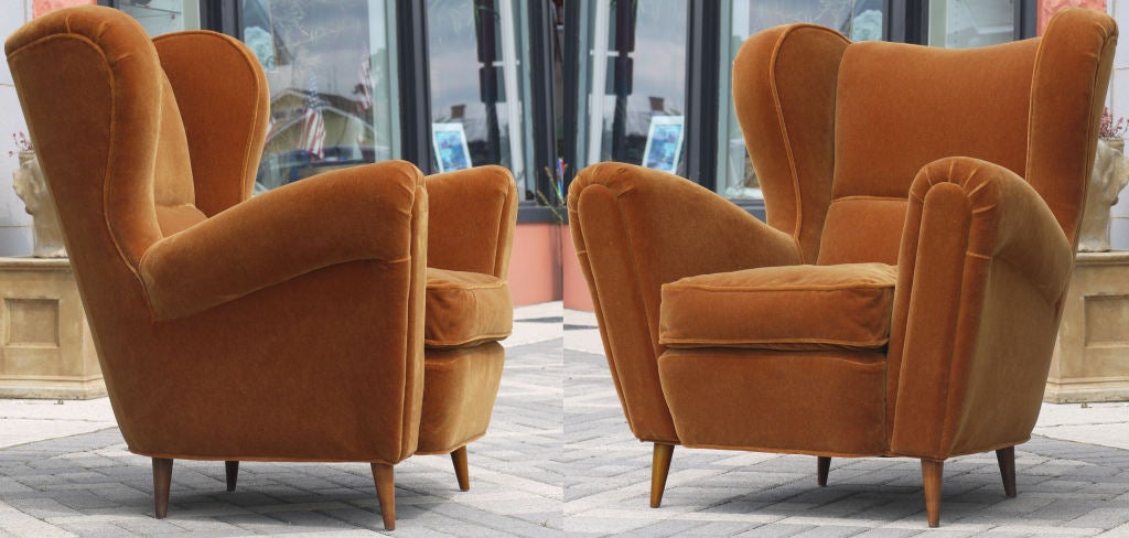 Large Sculpted winged club chairs in a dark apricot mohair attributed to Guglielmo Ulrich.  Stunning attention to details, and one of the nicest built chairs I've come across.