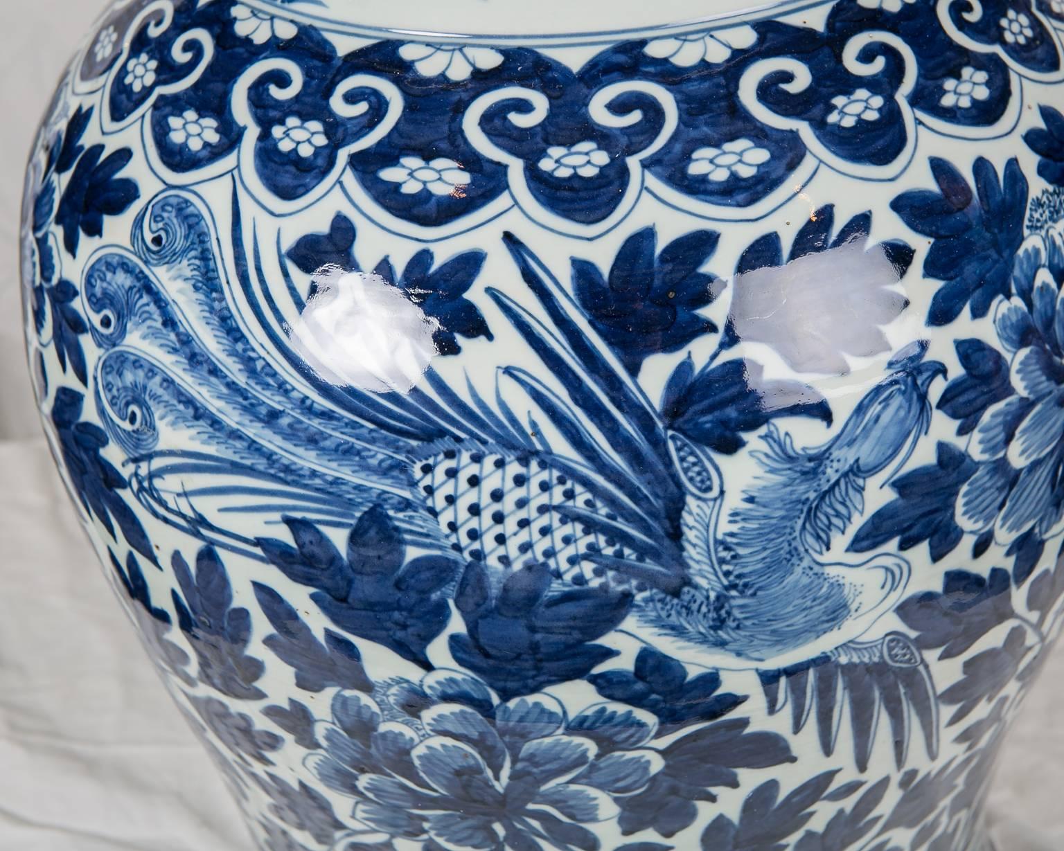 This monumental pair of Chinese Blue and White porcelain ginger jars are decorated in deep cobalt blue and feature phoenix among peonies. In Chinese tradition the phoenix only appear to announce good fortune and swift success. When depicted with