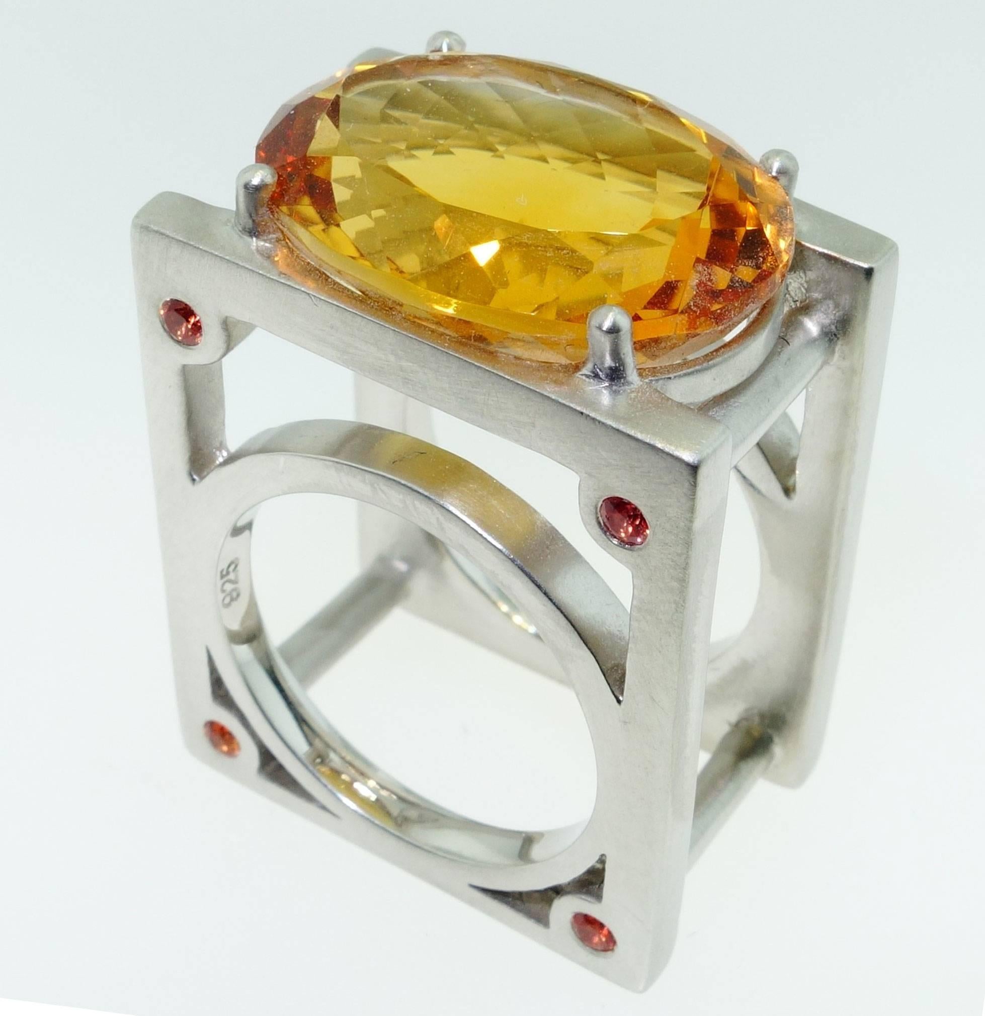 Sensational Citrine Ring set with a large 18 Carat oval facet-cut Citrine and 8 'rivets' set with small orange sapphires, in a unique Industrial style Sterling Silver Rhodium Tarnish-resistant mounting. More fabulous in person and so comfortable to