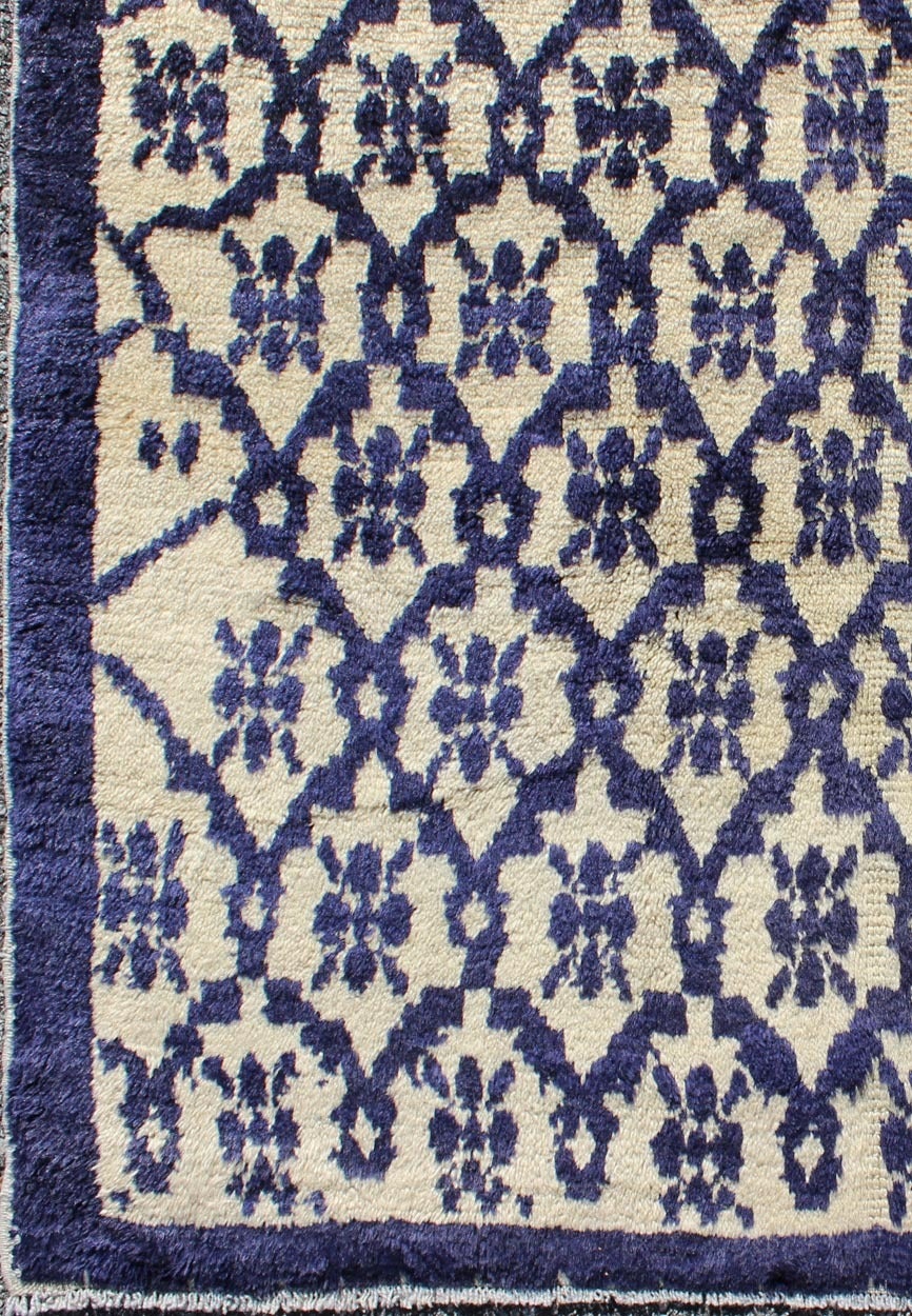 This unique vintage Tulu displays a subgeometric, modern design. The bold dark and medium blue presents well on a light ivory interior. 
 Measures: 3'11 x 6'8.