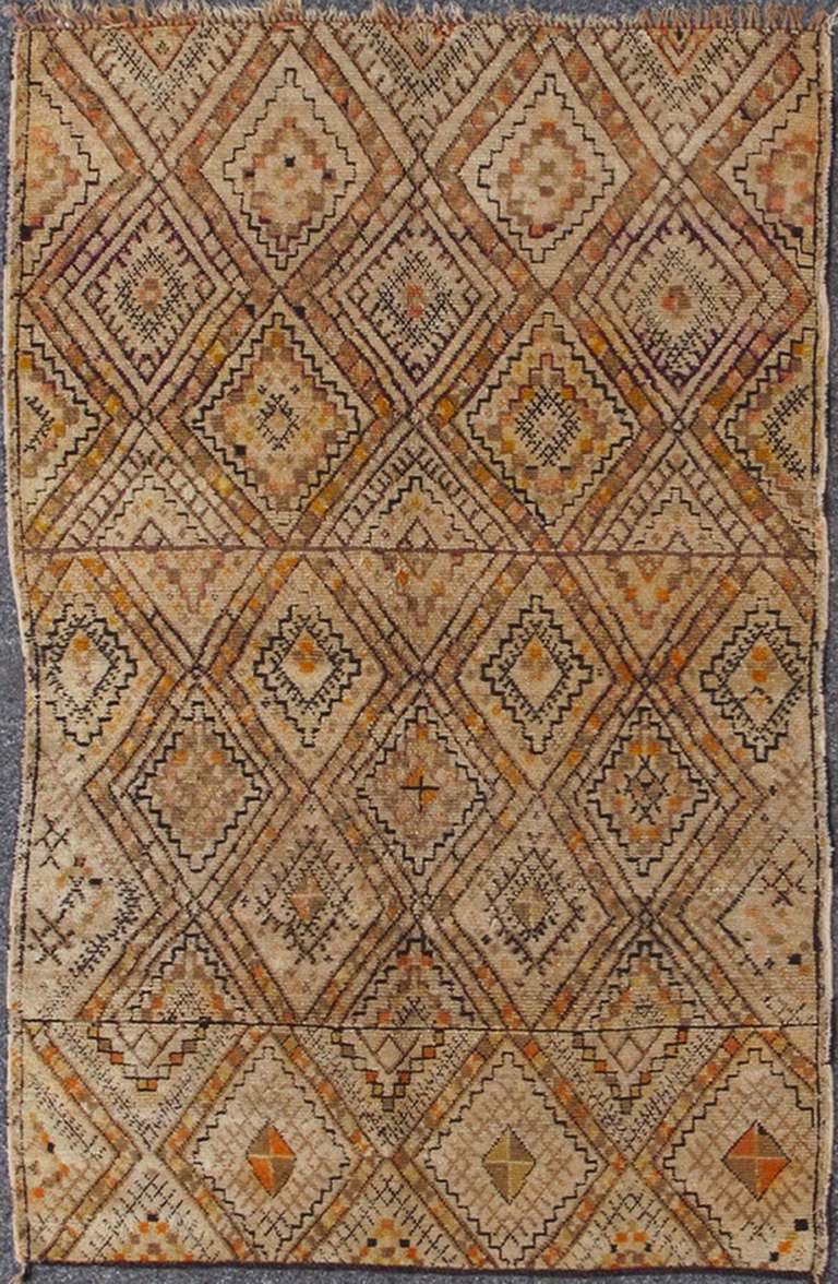 Rendered in various shapes with a spotted and speckled assortment of rich colors of orange and black, this very unique Moroccan has multiple diamond shapes with colors that change randomly. This rug is a good example of artistic and original village