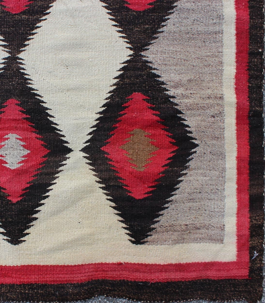 This intriguing vintage Navajo rug was woven in the United States during the first half of the 20th Century. The exciting and unique composition boasts a captivating geometric composition with an all-over diamond design. The range of colors includes