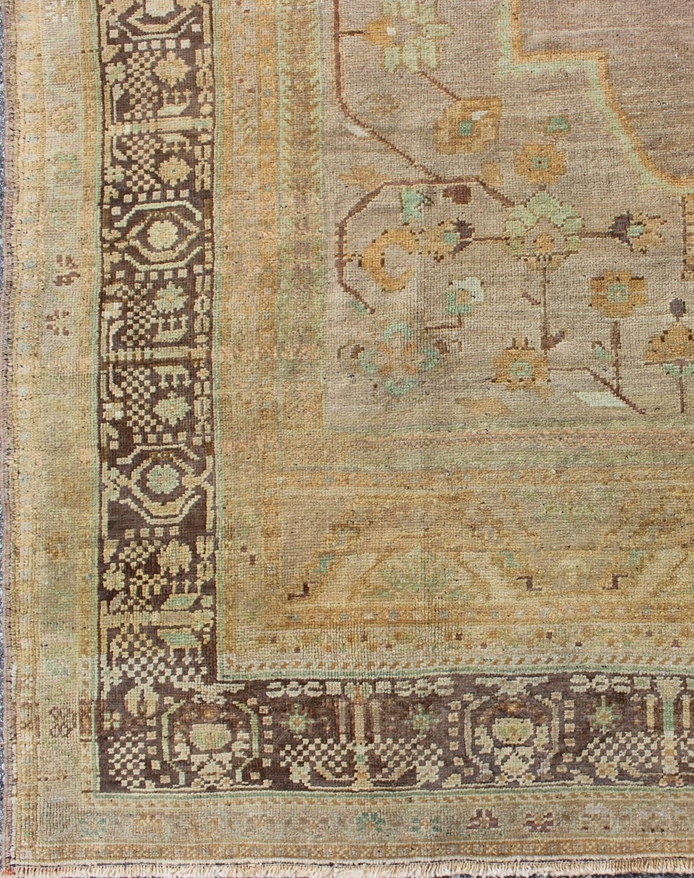 This beautiful Oushak showcases a unique color pallet of elegant gold, lavender, gray and soft purple, accented by pale blue, sage green, and highlighted by light brown and mocha colors. A delicate center medallion accentuates a botanic theme and is