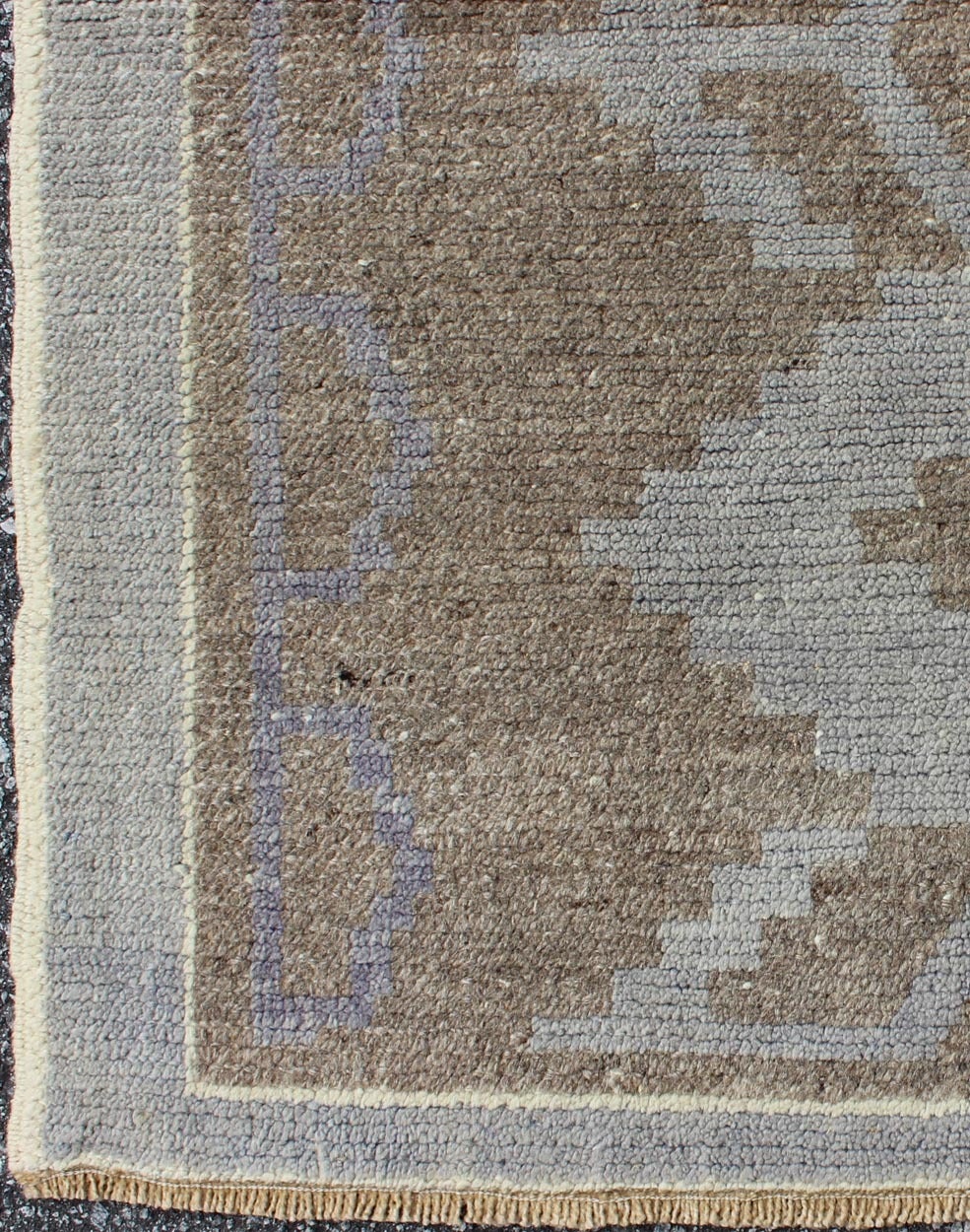 This vintage Turkish rug from Konya is characterized by an appealing modern design and contemporary color combination. The various blends of slate gray and light brown emphasize the motifs along the main body of this unique rug. This rug has been