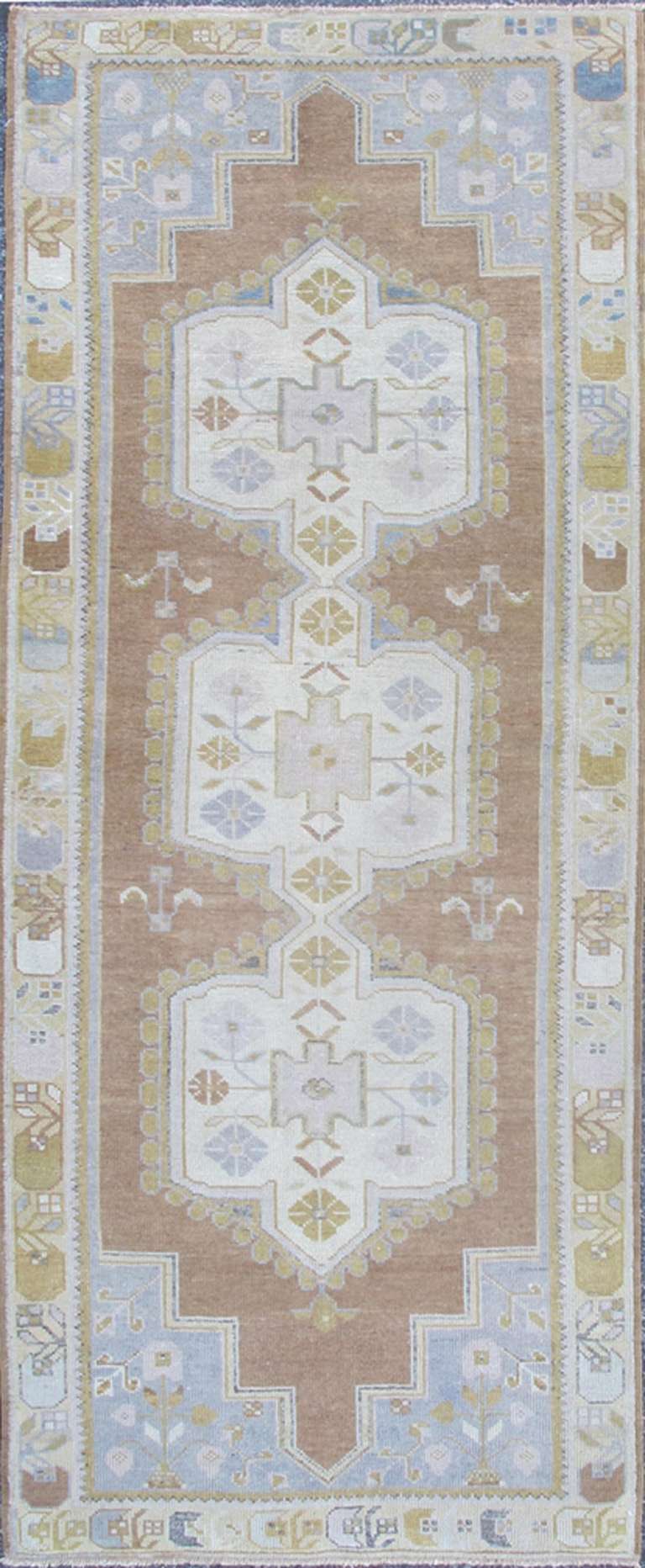 This magnificent Oushak beautifully illustrates the impressive craftsmanship and design of Turkish weavers. This Muted design gives the illusion of large muted medallions flowing through the rugs center field of grayish, taupe hues. Linear branches